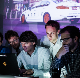 Four Aptiv employees looking at a laptop