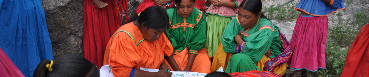 Three indigenous women writing on a paper