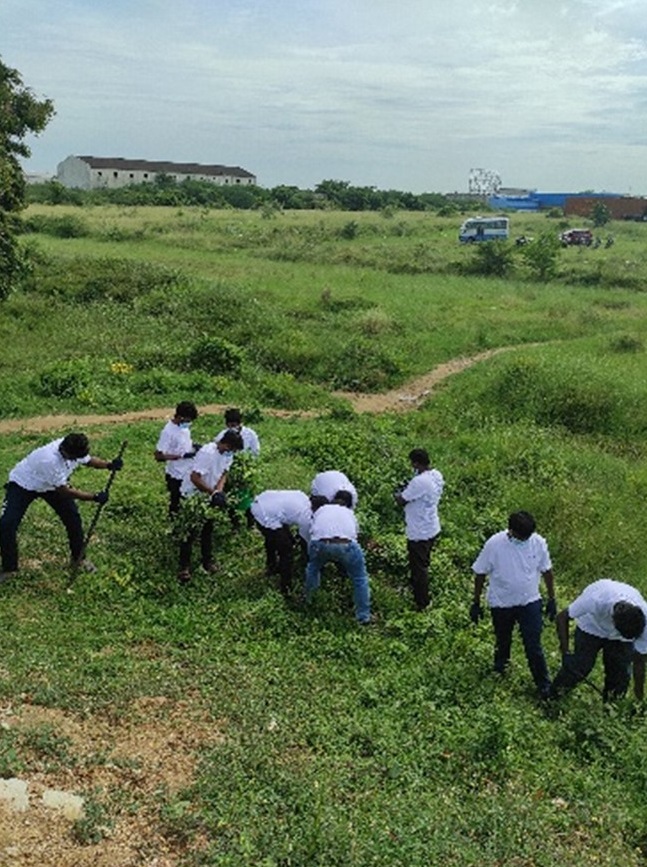 Empleados de Aptiv limpiando el perímetro de un lago local en Chennai, India