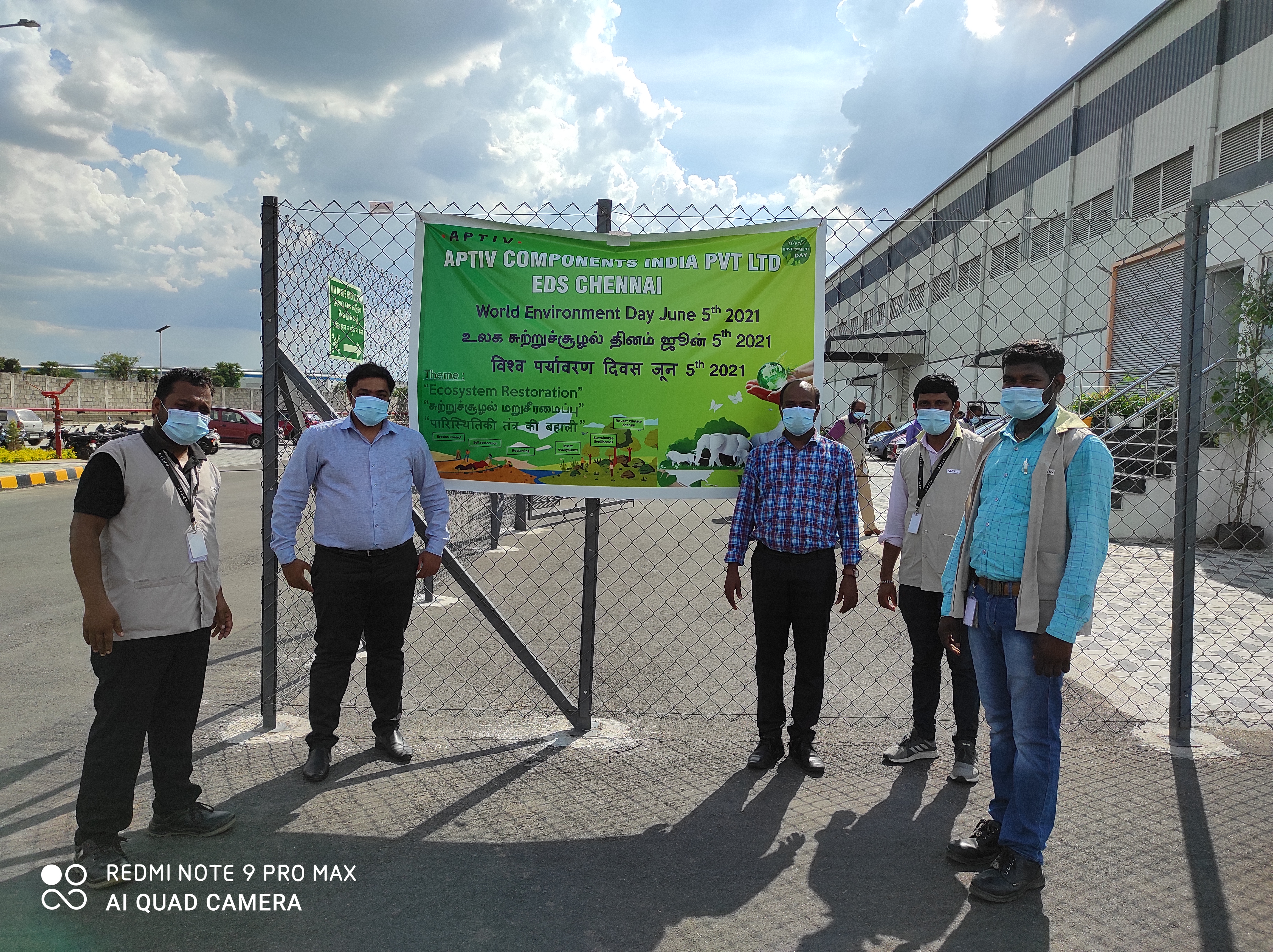 Aptiv employees with educational banner about Aptiv sustainability commitments