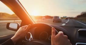 Hands of car driver on steering wheel