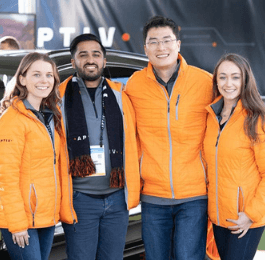 Four Aptiv employees wearing orange jackets